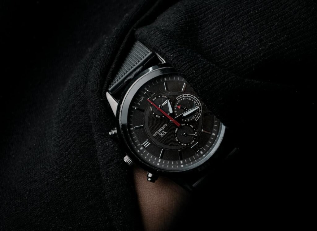 a man wearing a watch in black suite, closeup shot of wrist watch.